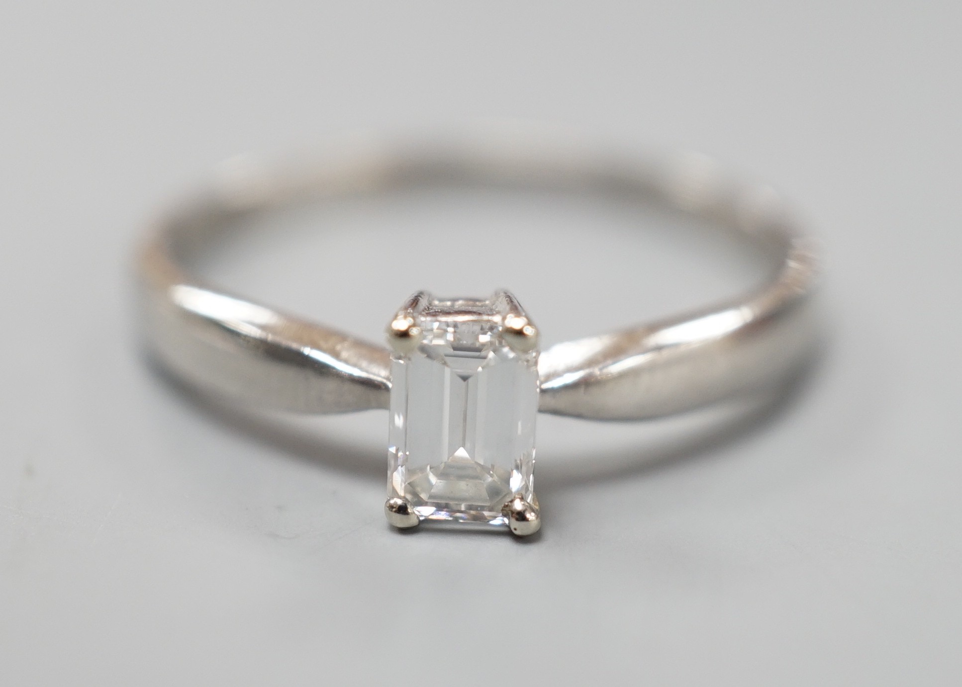 A modern platinum and solitaire emerald cut diamond set ring, size P/Q, gross weight 3.2 grams